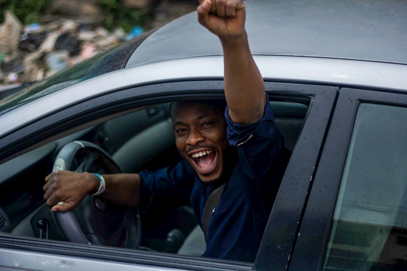 A new driver cheering out of the car window after passing