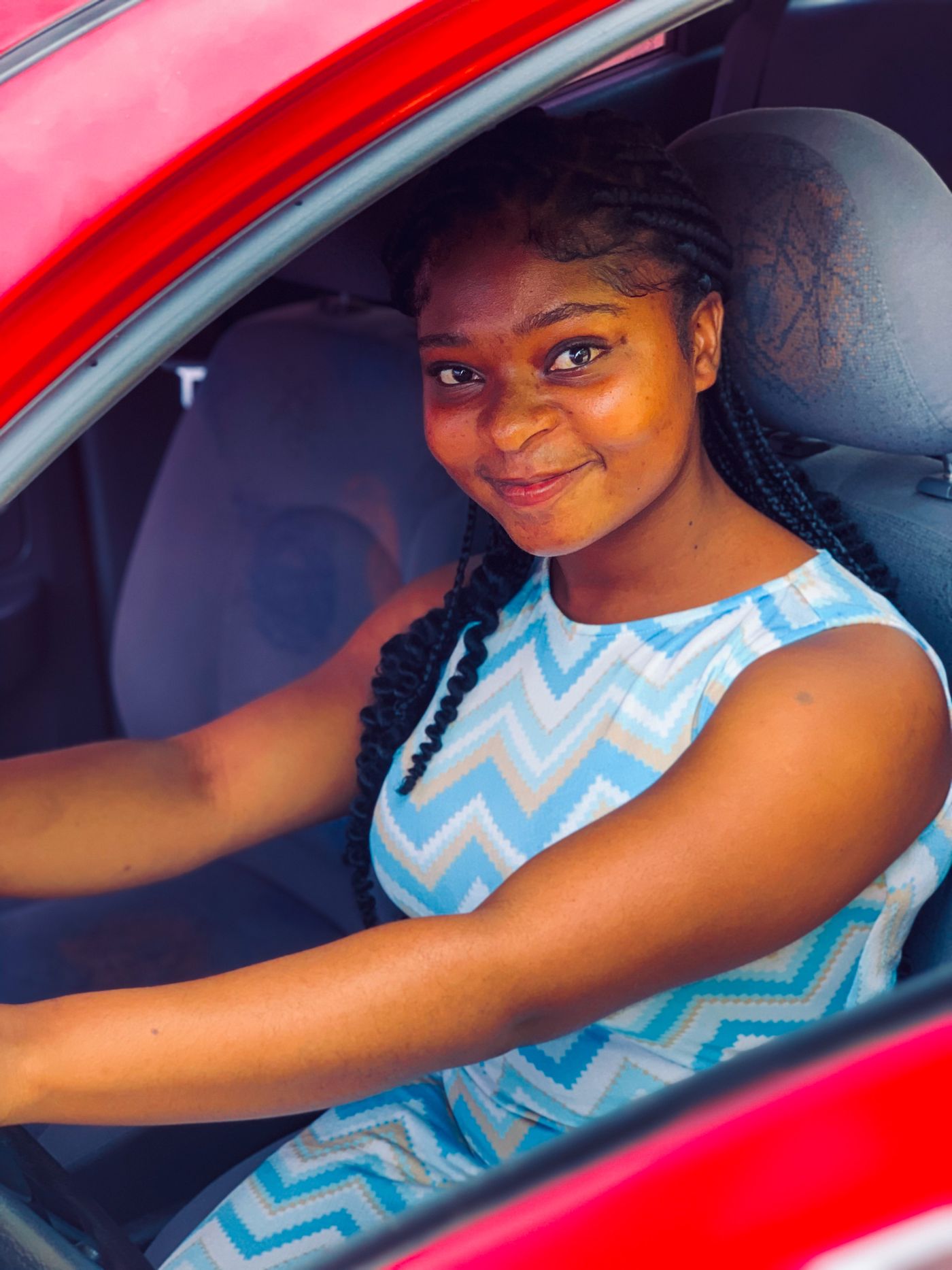 A smiling learner driver in the driver's seat